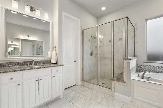 a bathroom with a granite countertop sink a mirror and a shower