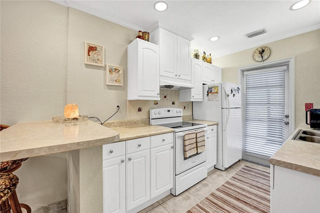 770 East Camino Real, Unit 3 Boca Raton, FL 33432 - Photo 12 of 34 a kitchen with white cabinets sink and white appliances