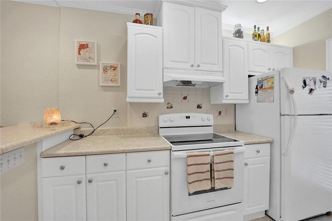 770 East Camino Real, Unit 3 Boca Raton, FL 33432 - Photo 13 of 34 a kitchen with white cabinets and white appliances