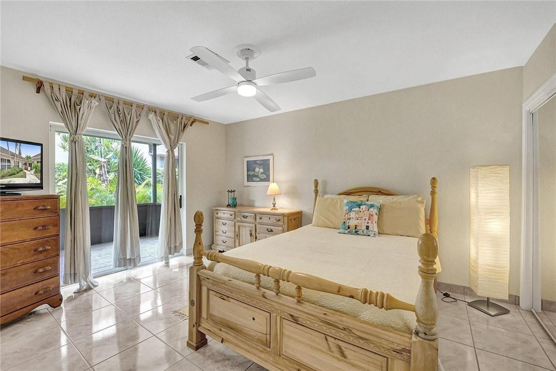 770 East Camino Real, Unit 3 Boca Raton, FL 33432 - Photo 20 of 34 a bedroom with a large bed and a flat tv screen on dresser