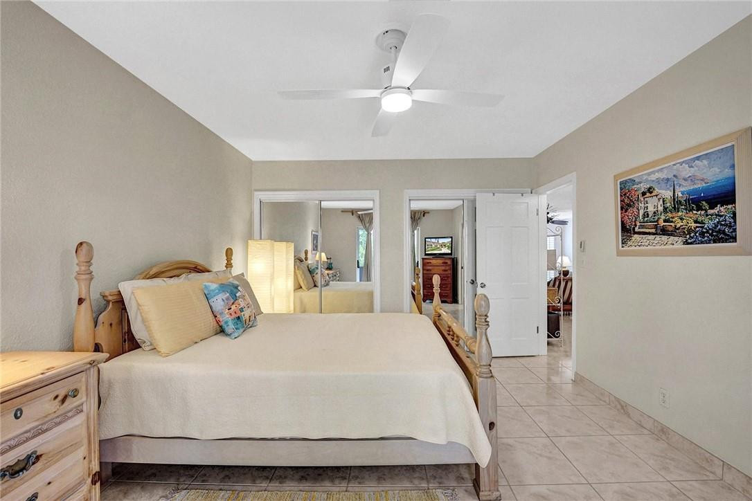 770 East Camino Real, Unit 3 Boca Raton, FL 33432 - Photo 22 of 34 a bedroom with a large bed and a chandelier