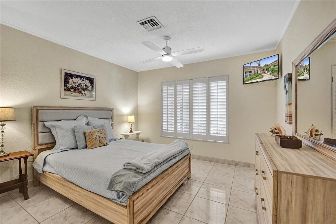 770 East Camino Real, Unit 3 Boca Raton, FL 33432 - Photo 25 of 34 a bedroom with a bed and a chandelier