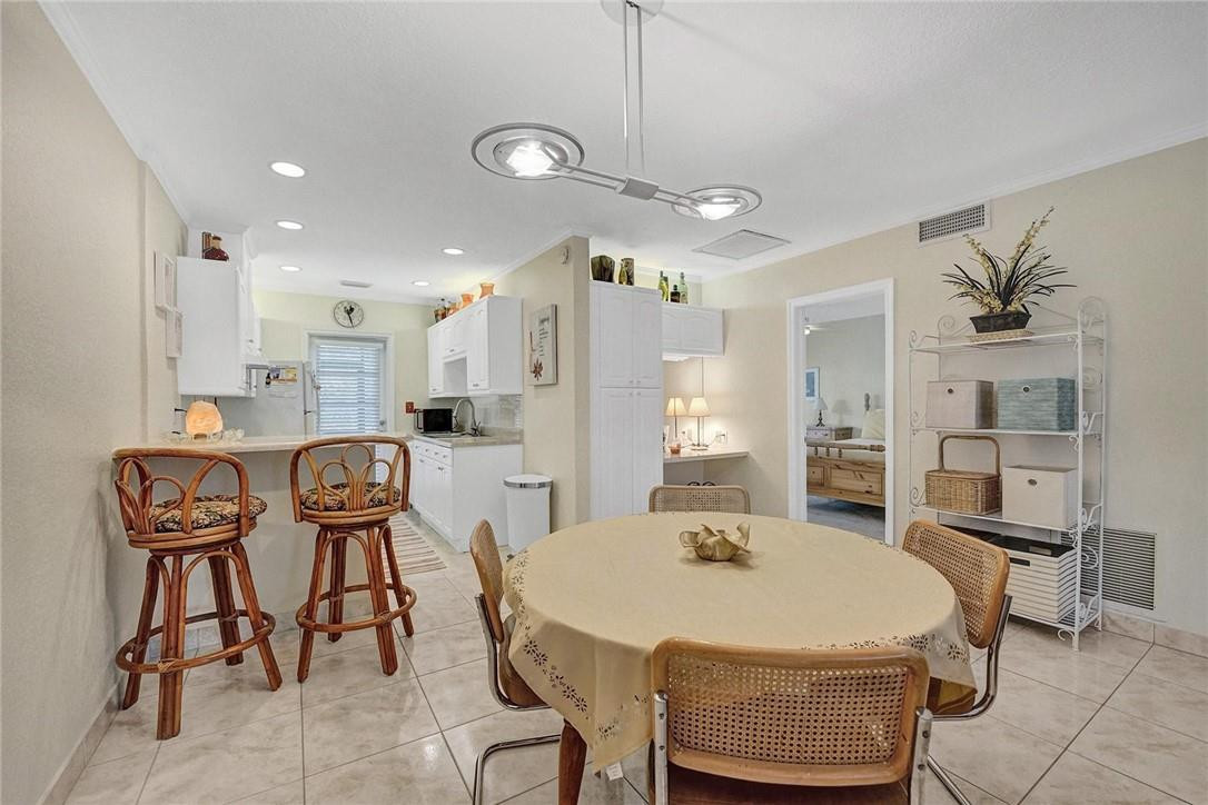 770 East Camino Real, Unit 3 Boca Raton, FL 33432 - Photo 10 of 34 a kitchen with kitchen island a dining table chairs sink and cabinets