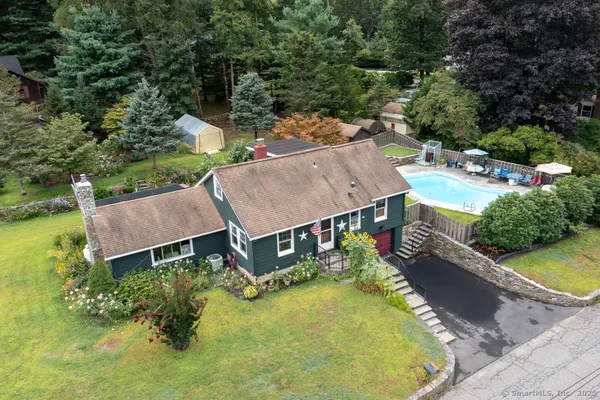 an aerial view of a house with swimming pool and garden