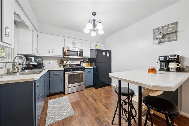 a kitchen with stainless steel appliances a table chairs and a refrigerator