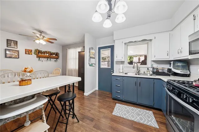 a kitchen with a dining table cabinets appliances and a window