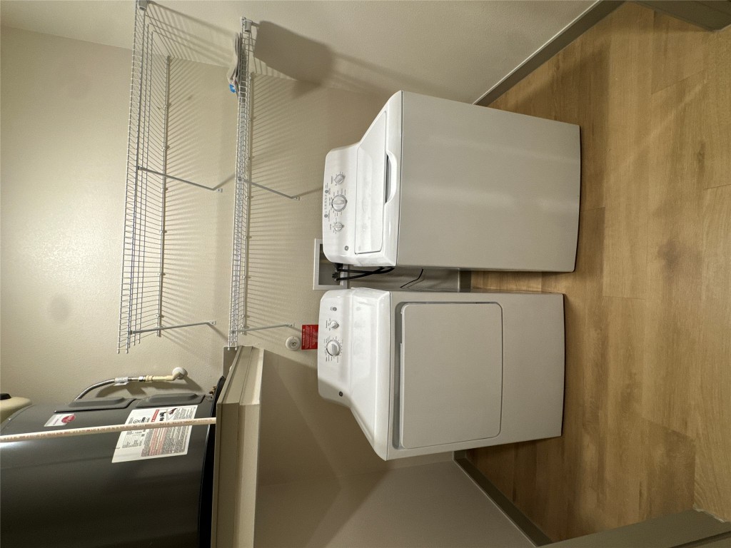 691 Union Chapel Road, Unit C1 Cedar Creek, TX 78612 - Photo 3 of 35 Laundry area with light wood-style floors, washing machine and clothes dryer, and heating unit