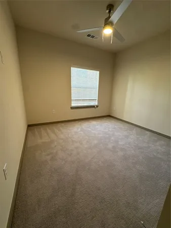 an empty room with windows and ceiling fan