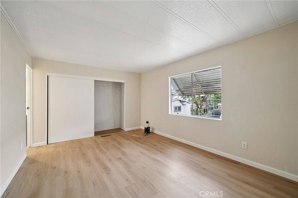 3663 Buchanan Street, Unit 130 Riverside, CA 92503 - Photo 15 of 26 a view of an empty room with wooden floor and a window
