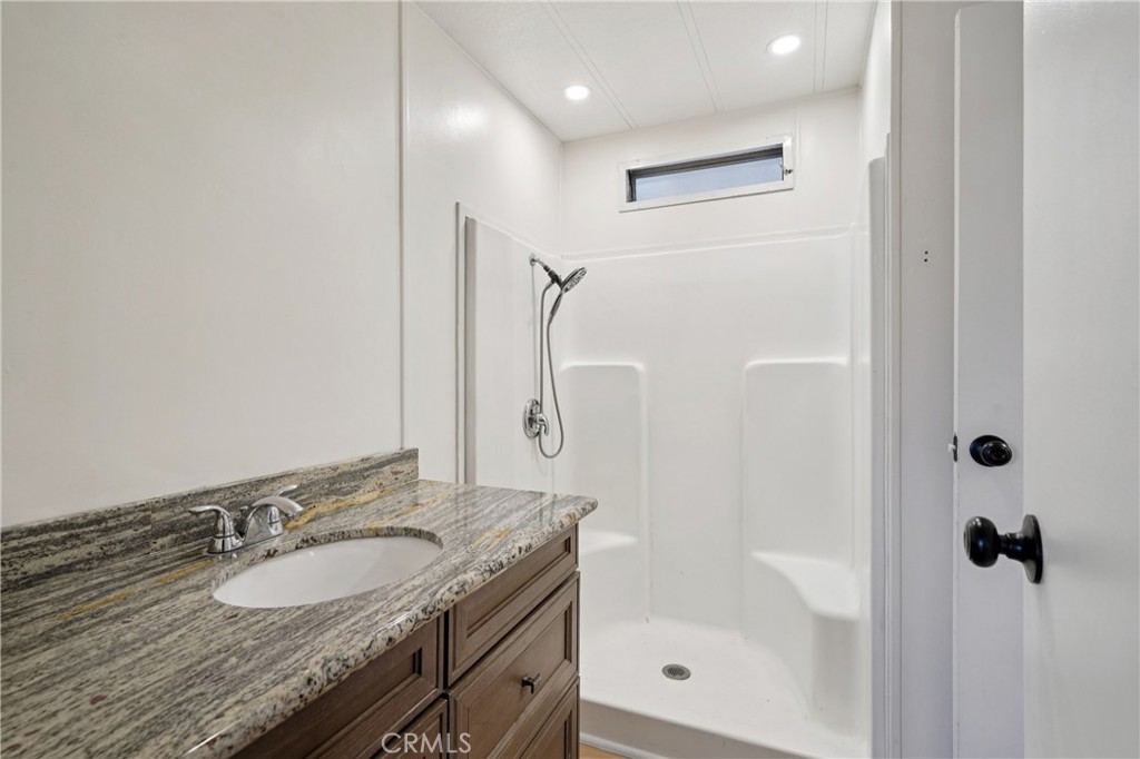 3663 Buchanan Street, Unit 130 Riverside, CA 92503 - Photo 20 of 26 a bathroom with a granite countertop sink a mirror and shower