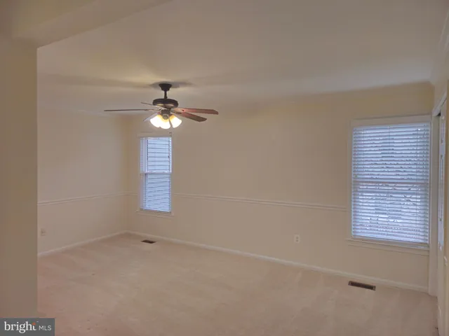 an empty room with a chandelier fan
