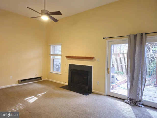 an empty room with windows and fireplace