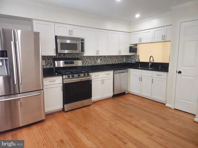 a kitchen with granite countertop stainless steel appliances and wooden cabinets