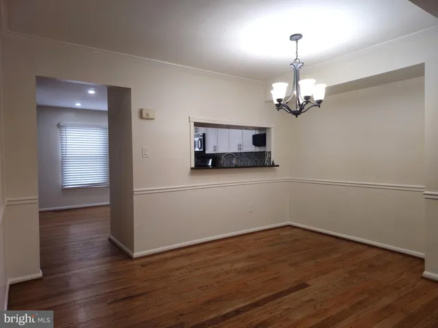a view of a room with wooden floor and chandelier