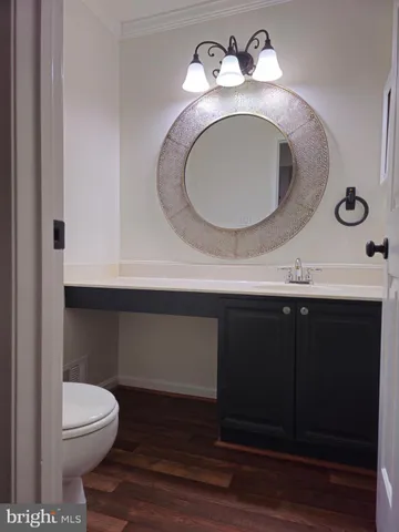 a bathroom with a toilet sink vanity and mirror