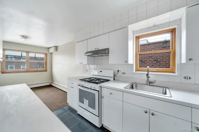 a kitchen with white cabinets and appliances