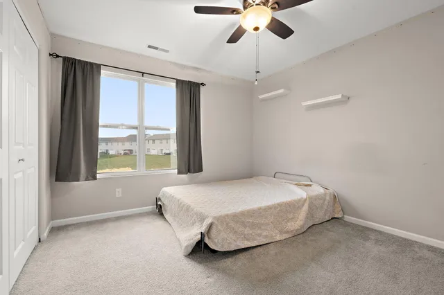 a spacious bedroom with a bed and a large window