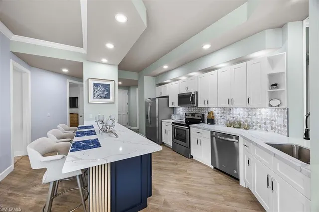 a large kitchen with stainless steel appliances kitchen island granite countertop a sink and cabinets
