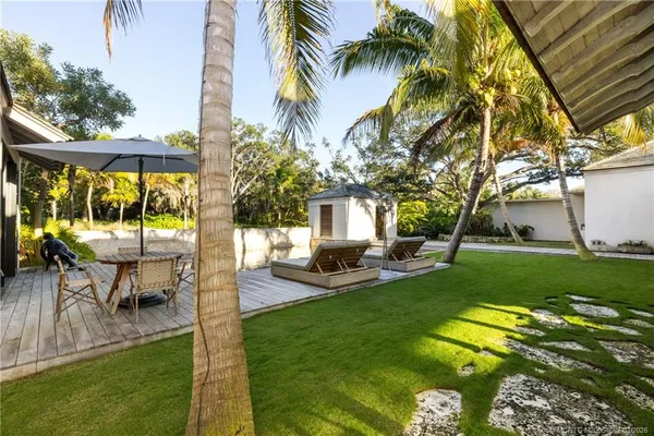 a patio with table and chairs and potted plants