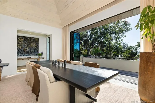 a view of a dining room with furniture a kitchen and chandelier