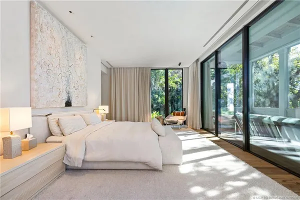 a living room with furniture a flat screen tv and a large window
