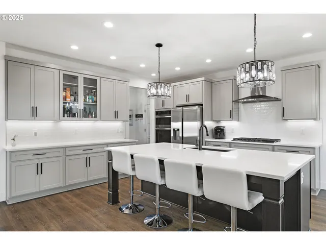 a kitchen with kitchen island granite countertop a sink and white cabinets