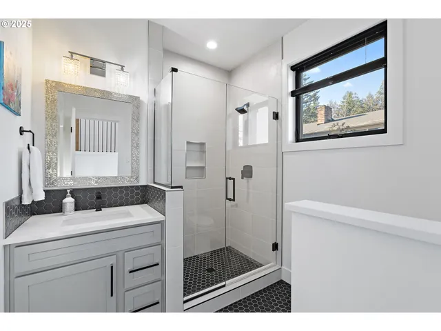a bathroom with a shower sink and mirror