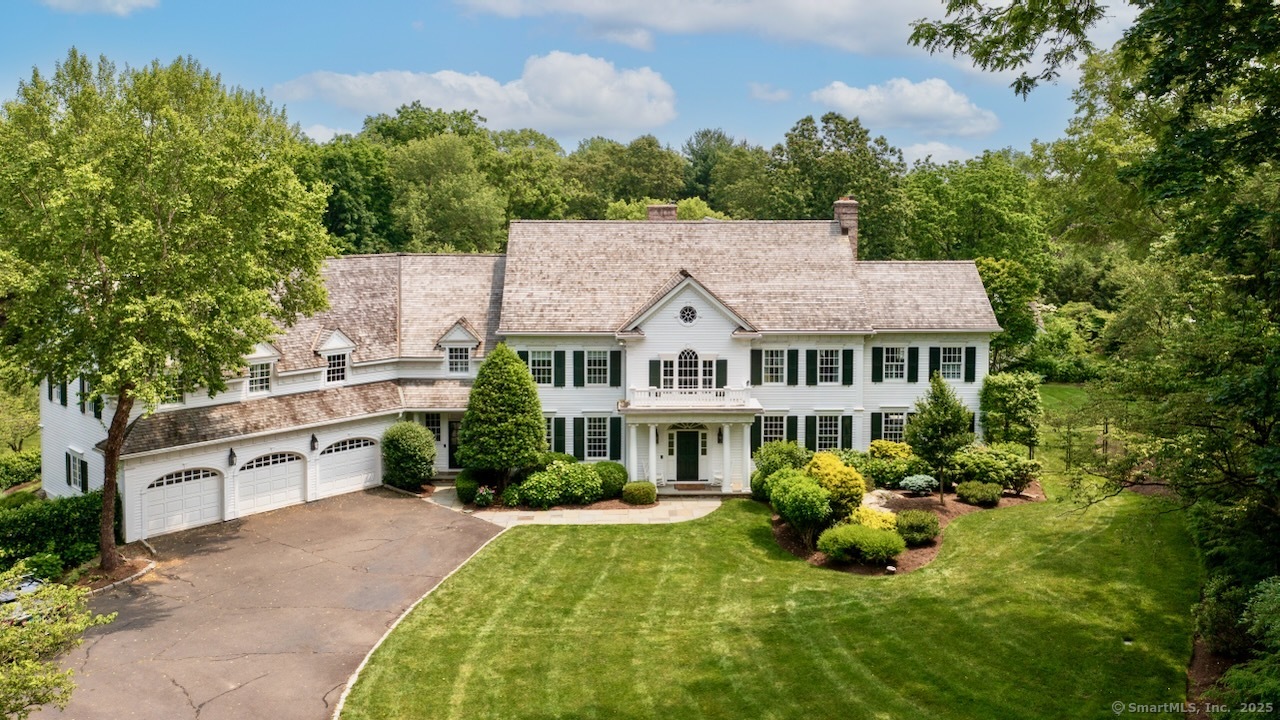 a view of a house with a big yard plants and large trees