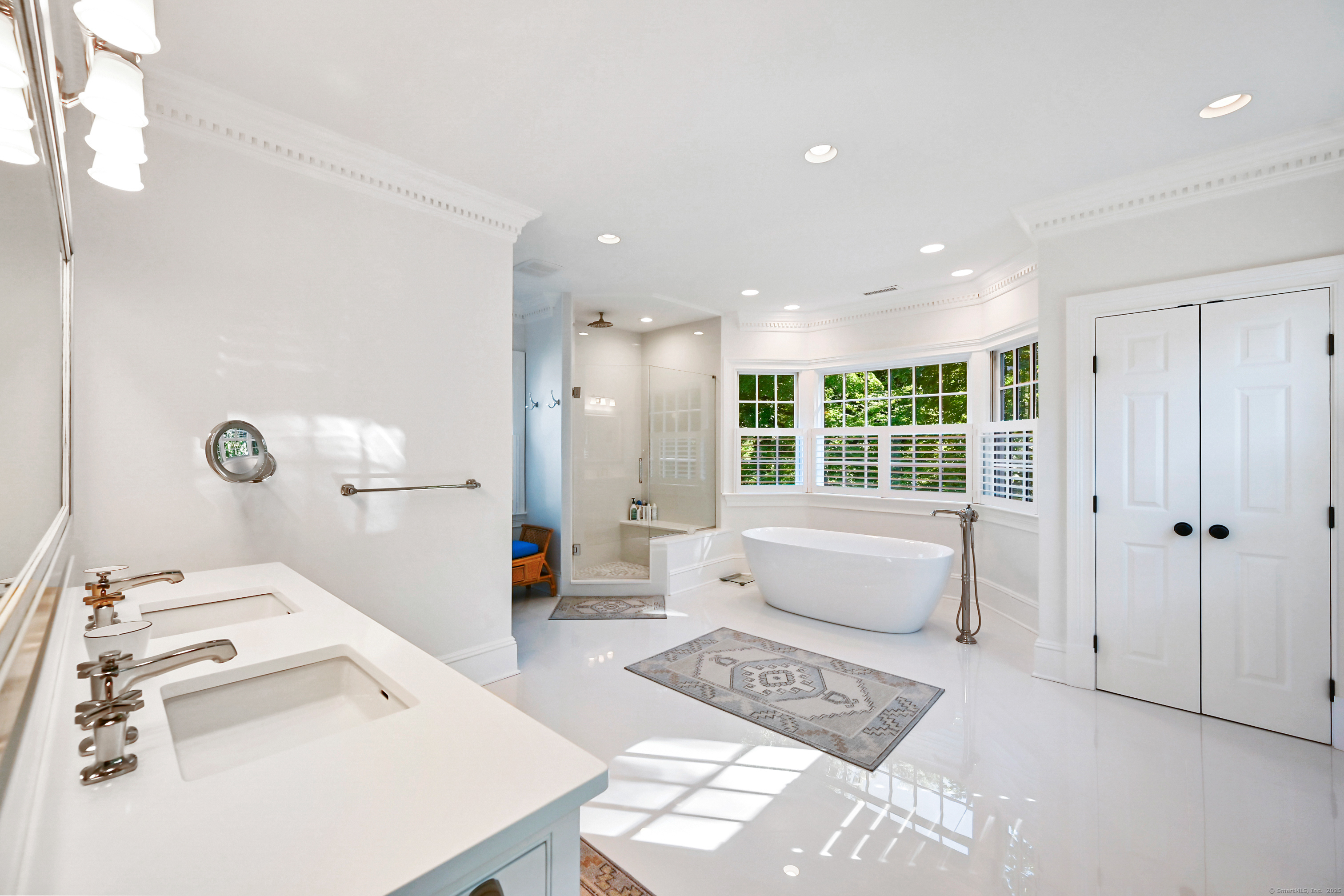 1084 Sturges Highway Fairfield, CT 06880 - Photo 19 of 40 a spacious bedroom with a bed a couch and a window