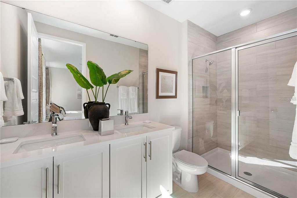 7834 Spectrum Drive Reunion, FL 34747 - Photo 10 of 16 a bathroom with a granite countertop sink a toilet and shower