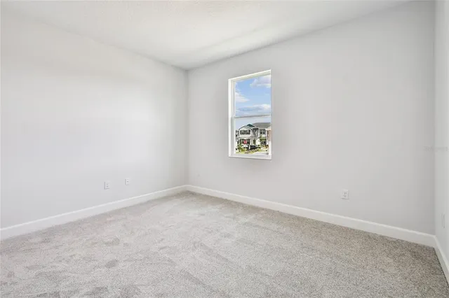 a view of an empty room with window wooden floor