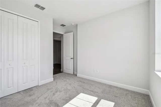 a white house with a yard and a large tree