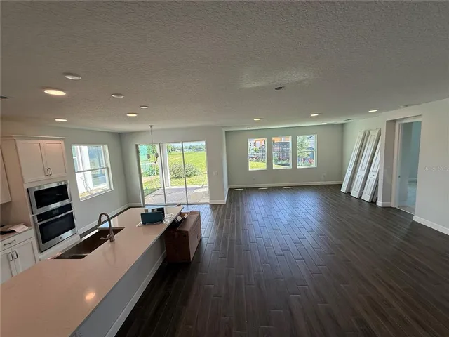 an open kitchen with white cabinets and wooden floor