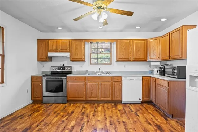 a kitchen with stainless steel appliances granite countertop a stove a sink and a refrigerator