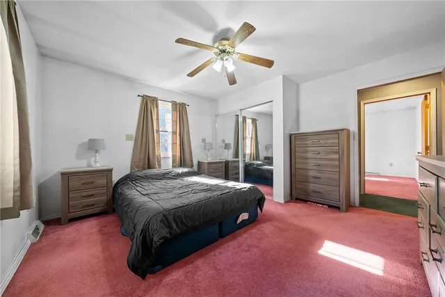 a spacious bedroom with a bed and a chandelier