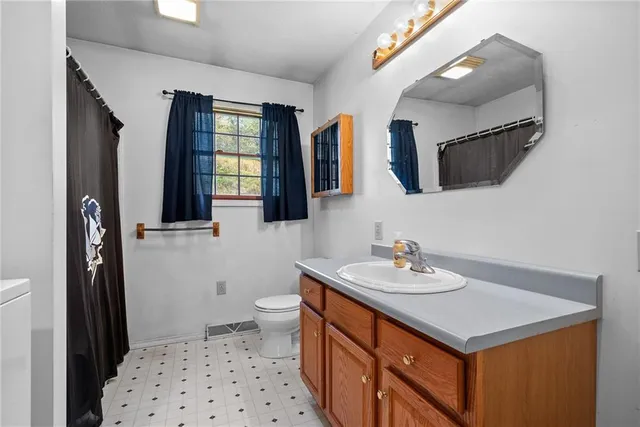 a bathroom with a sink a toilet a mirror and shower