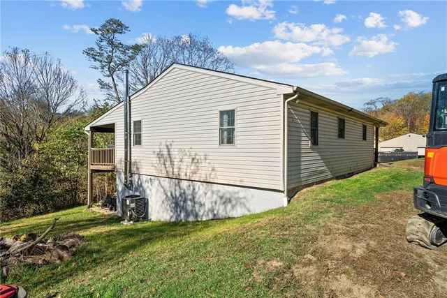 a view of backyard of house and car parked
