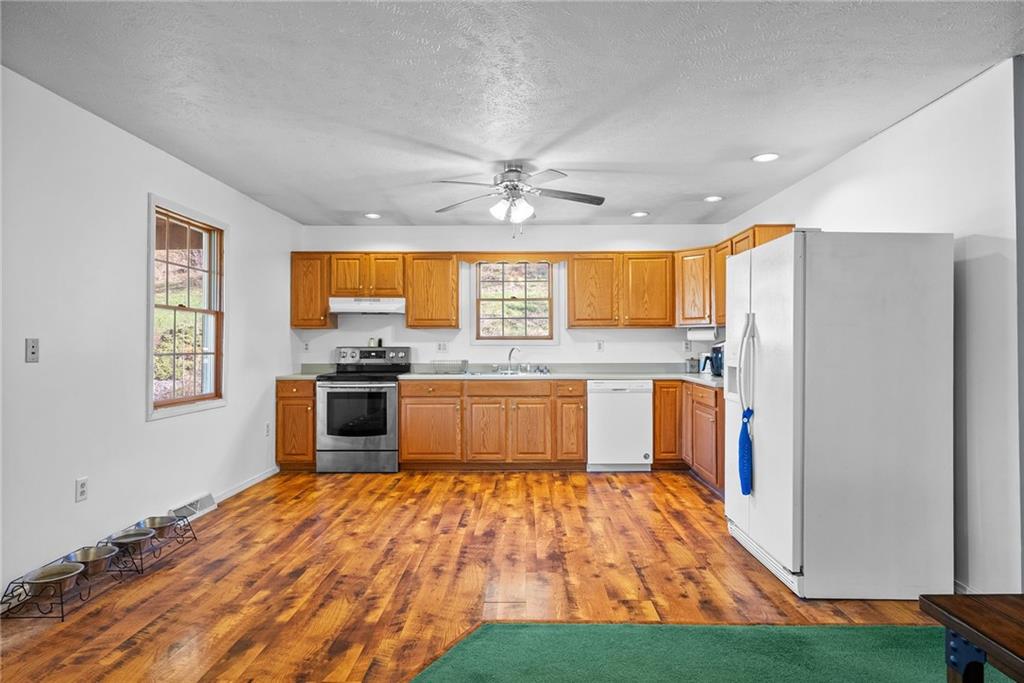 573 Shaffer Road Hookstown, PA 15050 - Photo 10 of 41 a large kitchen with stainless steel appliances granite countertop a stove a sink dishwasher and a refrigerator with wooden floor