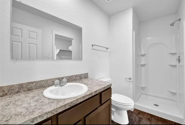 a bathroom with a granite countertop sink a toilet and shower