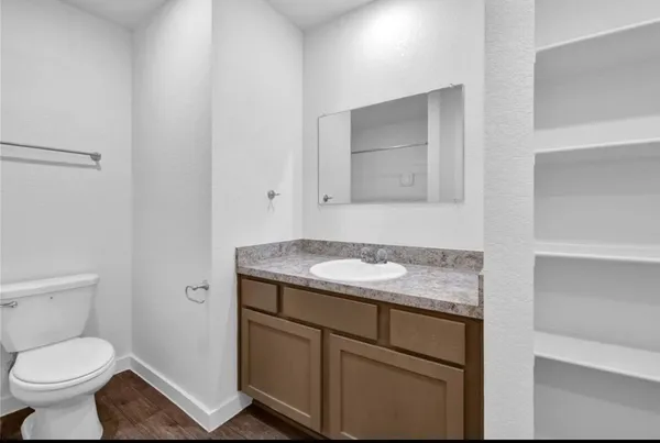 a bathroom with a granite countertop toilet sink and mirror