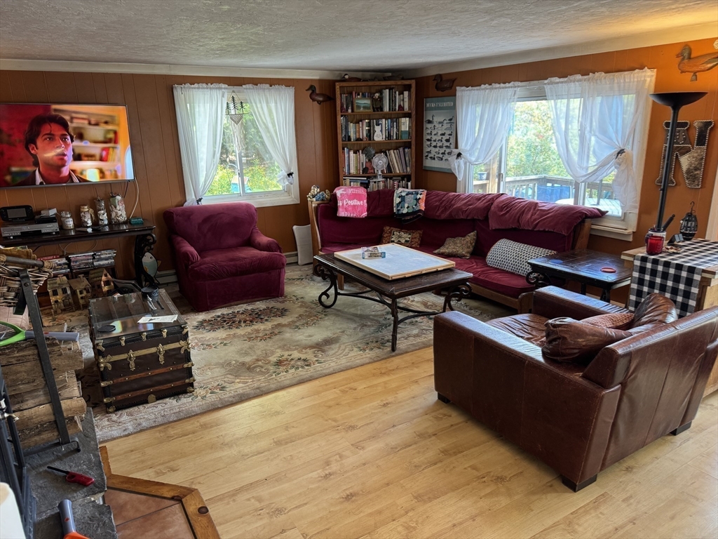 116 Brookfield Road Brimfield, MA 01010 - Photo 12 of 26 a living room with furniture a flat screen tv and a floor to ceiling window
