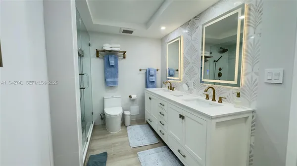 a bathroom with a double vanity sink mirror and toilet