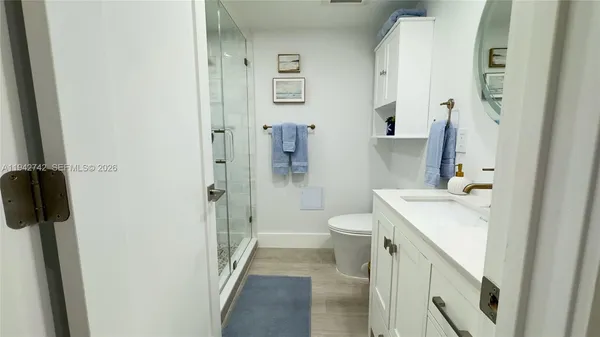 a bathroom with a sink a toilet and shower