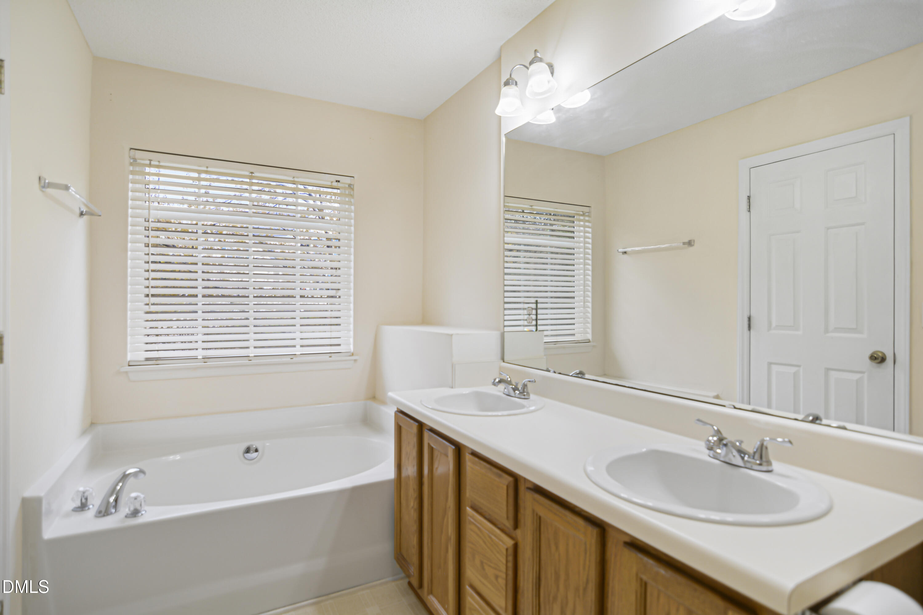 2241 Spruce Shadows Lane Raleigh, NC 27614 - Photo 18 of 29 a bathroom with a tub double sink window and mirror