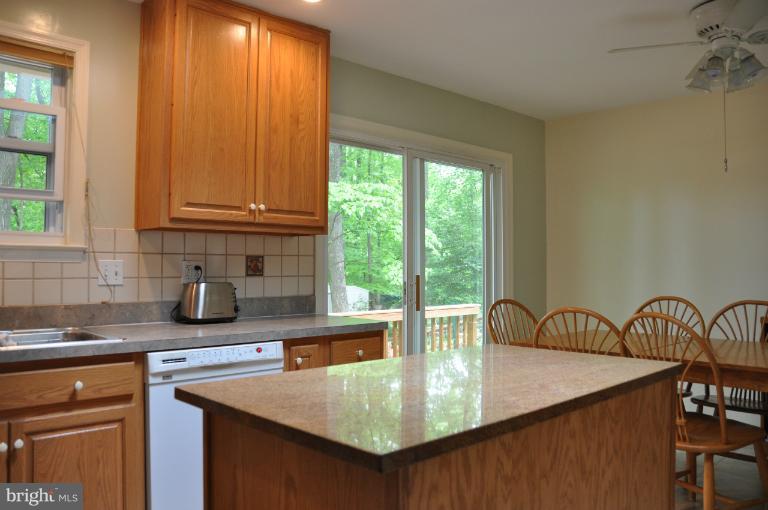 8612 Victoria Road Springfield, VA 22151 - Photo 14 of 25 a kitchen with stainless steel appliances granite countertop a sink a stove and a wooden cabinets