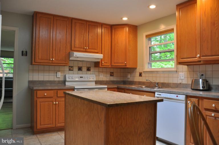 8612 Victoria Road Springfield, VA 22151 - Photo 16 of 25 a kitchen with stainless steel appliances granite countertop wooden cabinets a sink and a stove