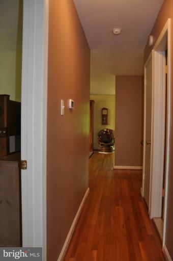 8612 Victoria Road Springfield, VA 22151 - Photo 19 of 25 a view of a hallway with wooden floor and a living room