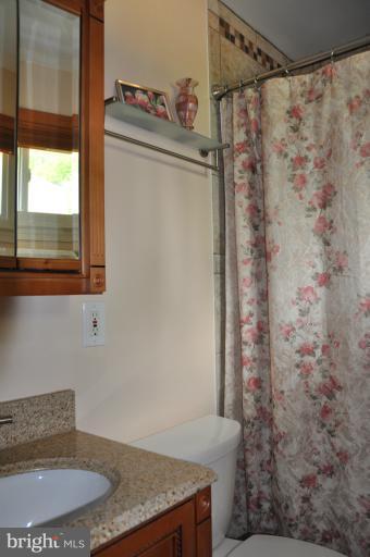 8612 Victoria Road Springfield, VA 22151 - Photo 24 of 25 a bathroom with a granite countertop sink and a mirror