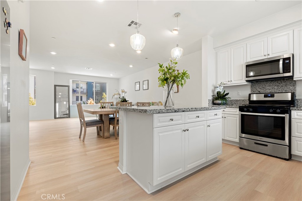 185 Steely Irvine, CA 92614 - Photo 6 of 28 a kitchen with white cabinets and stainless steel appliances