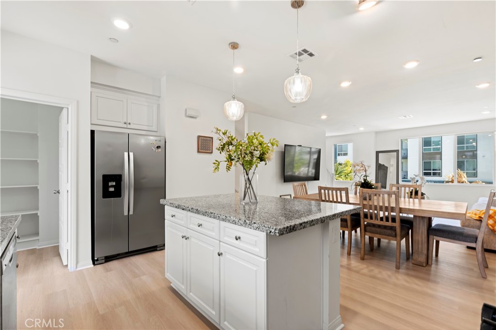 185 Steely Irvine, CA 92614 - Photo 7 of 28 a kitchen with stainless steel appliances granite countertop dining table chairs and wooden floor